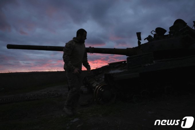 지난 1월 31일(현지시간) 우크라이나 이지움에서 한 군인이 해질녘 파괴된 탱크 주위를 걷고 있다. /로이터=뉴스1 