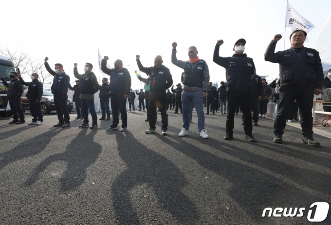 (의왕=뉴스1) 신웅수 기자 = 민주노총 공공운수노조 화물연대본부 조합원들이 9일 오후 경기 의왕시 화물연대 서울경기지역본부에서 총파업 철회 발표 후 구호를 외치고 있다.  화물연대는 파업 16일 만에 총파업을 철회하고 업무에 복귀하기로 했다. 2022.12.9/뉴스1  Copyright (C) 뉴스1. All rights reserved. 무단 전재 및 재배포 금지.