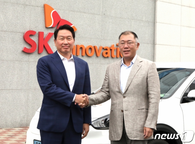 (서울=뉴스1) = 최태원 SK그룹 회장(왼쪽)과 정의선 현대차그룹 수석부회장이 7일 충남 서산 SK온 배터리 공장에서 SK온 배터리가 탑재된 '니로EV' 앞에서 악수하고 있다. (SK·현대차 제공) 2020.7.7/뉴스1