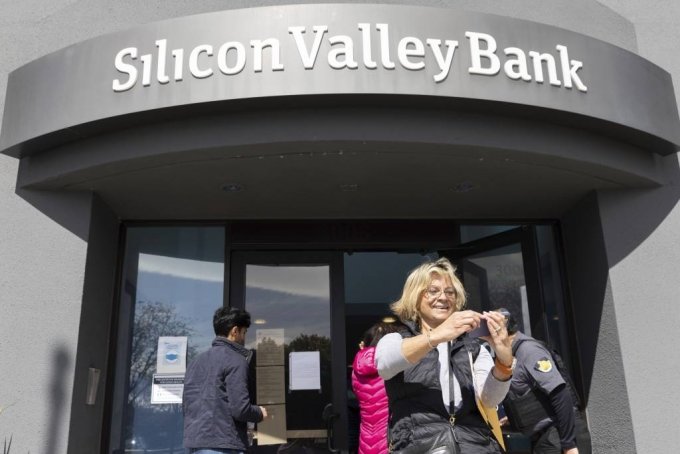 [샌타클래라=AP/뉴시스] 13일(현지시간) 미 캘리포니아주 샌타클래라 실리콘밸리은행(SVB) 본점 앞에서 대기하다가 입장하게 된 여성이 셀카를 찍고 있다. 예금주들은 돈을 찾기 위해 은행 밖에서 줄을 서서 대기했으며 연방정부는 SVB 예금주들이 인출할 수 있는 자금을 확보하기 위해 SVB에 개입한 것으로 알려졌다. 2023.03.14.
