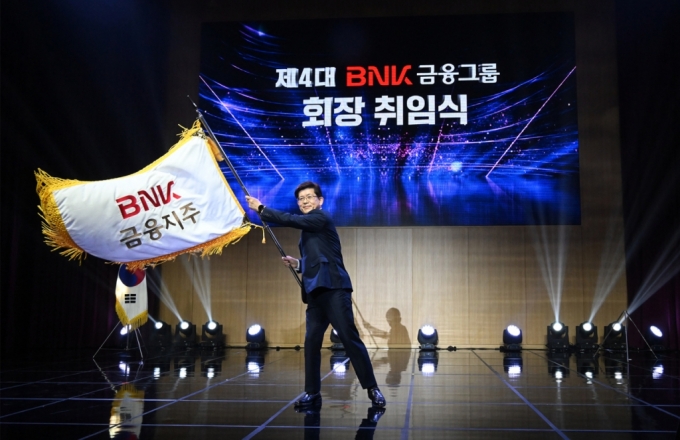 BNK금융지주는 17일 오후 본사 2층 대강당에서 제4대 빈대인 회장의 취임식을 개최했다. 취임식에서 빈대인 신임 회장이 BNK금융 깃발을 흔들고 있다/사진=BNK금융 제공