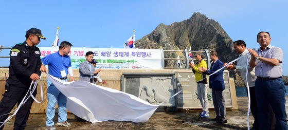 =2015년8월7일 연영진 해양수산부 해양정책실장(왼쪽 세번째)와 내빈들이 7일 독도에서 열린 광복 70주년 기념 독도 해양 생태계 복원행사에서 독도강치 기원 벽화 제막식을 하고 있다. 기원벽화에는 '강치야 독도야 동해바다야! 사라져간 강치를 기념하여 비를 세우노니 우리바다 영토지킴이가 되어 주소서' 문구가 적혀있다. 2015.8.7/뉴스1