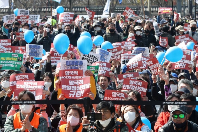 [서울=뉴시스] 김진아 기자 = 한일역사정의평화행동 관계자들이 18일 오후 서울 중구 서울광장에서 열린 '대일 굴욕외교 규탄 범국민대회'에서 구호를 외치고 있다. (공동취재사진) 2023.03.18.