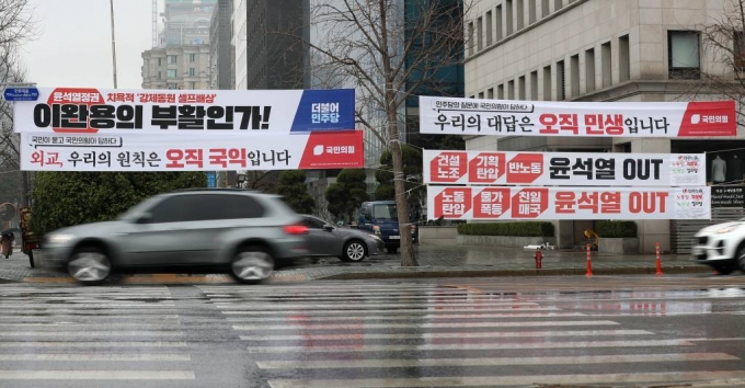 [서울=뉴시스] 이영환 기자 = 12일 오전 서울 여의도 국회 앞 횡단보도에 각 정당들의 현수막이 게시되어 있다. 지난해 6월 옥외광고물법 개정안 시행으로 정당의 정책이나 정치적 현안에 대해 표시하는 현수막은 별도 허가나 신고없이 15일간 게시할 수 있게 됐지만 현수막이 우후죽순 설치돼 도시미관 훼손과 안전사고 우려 등이 제기돼왔다. 이에 서울시는 관련법 개정 건의와 함께 정당 현수막 설치·관리 가이드라인을 마련하고 자치구의 현수막 정비를 지원키로 했다. 2023.03.12.