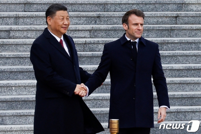  시진핑 중국 국가주석(왼쪽)과 에마뉘엘 마크롱 프랑스 대통령이 6일 정상회담에 앞서 중국 베이징 인민대회당 앞에서 만나 악수하고 있다.  /로이터=뉴스1
