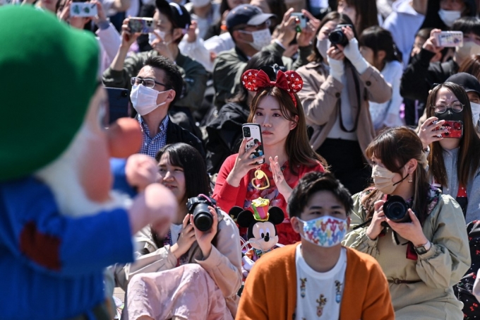 지난 10일 도쿄 디즈니랜드에서 방문객들이 퍼레이드를 구경하며 사진을 찍고 있다./AFPBBNews=뉴스1