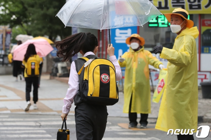 봄비가 내린 지난달 18일 오전 대구 중구의 한 초등학교 앞에서 우산을 쓴 어린이들이 등굣길 발걸음을 재촉하고 있다/사진=뉴스1