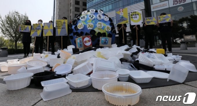녹색연합 활동가들이 20일 서울 송파구 배달의민족 앞에서 지구본 모형과 배달 플라스틱 쓰레기를 모아놓고 1회용 배달 플라스틱 쓰레기 문제 해결을 위해 배달앱의 사회적 책임을 촉구하는 기자회견을 하고 있다. 2021.4.20/뉴스1   