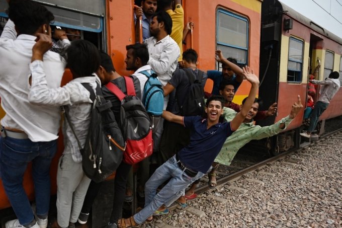 지난 4월 24일(현지시간) 인도 우타르프라데시주 로니의 한 철도역 부근에서 열차 이용객들이 기차에 매달려 있는 모습/AFPBBNews=뉴스1