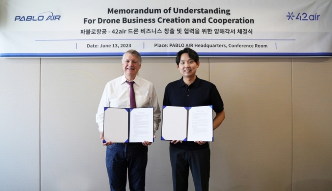 김영준 파블로항공 대표(오른쪽)와 행크 구슨 포티투에어 대표(왼쪽)가 파블로항공 송도 본사에서 협약 체결후 기념 촬영을 하고 있다./사진제공=파블로항공