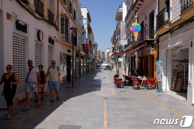 스페인 론다 시내에서 25일(현지시간) 관광객들이 쇼핑가에서 햇빛을 피해 그늘 아래를 걷고 있다. 스페인 남부는 이날 섭씨 43.8도를 기록하며 여름 첫 폭염이 찾아왔다. /로이터=뉴스1