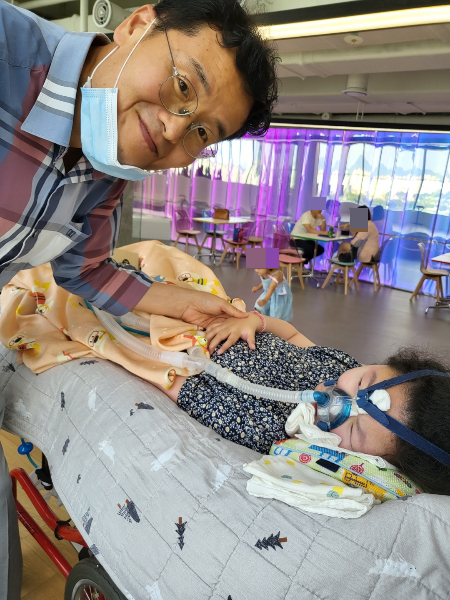 윤서연양 아버지 윤정호씨가 웃어보인다. 척수성근위축증을 앓는 딸 옆에서. 희귀하고 치료가 어려운 병이다. 치료제인 스핀라자 가격은 1억원이다. 단 한 번에 1억원, 누구도 감당하기 쉽지 않은 돈이다. 안 맞으면 호흡 곤란으로 죽을 수도 있기에, 아버지는 딸을 위해 기꺼이 주사를 맞혔다. 이토록 절박한 이들인데, 치료제 가격이 이리 비싸도 좋은 것일지./사진=윤정호씨 제공