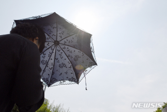 지난해 6월20일 광주 서구 풍암호수공원에서 한 시민이 햇빛을 피하기 위해 양산을 쓰고 산책하고 있다. 사진은 기사 내용과 직접적 관련 없음. /사진=뉴시스