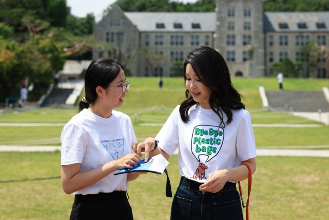 윤석열 대통령 부인 김건희 여사가 지난달 5일 서울 성북구 고려대학교 중앙광장에 마련된 바이바이플라스틱 캠페인 포토월을 찾은 학생에게 홍보 물품을 전달하고 있다. (사진=대통령실 제공) 2023.06.05. /사진=뉴시스