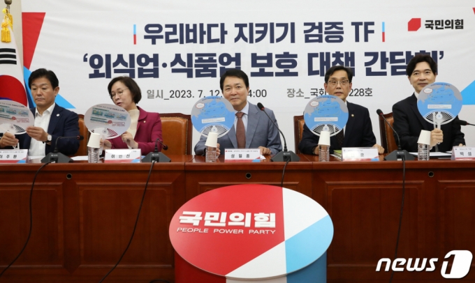 (서울=뉴스1) 송원영 기자 = 성일종 국민의힘 우리바다 지키기 검증 TF 위원장과 한훈 농림식품부 차관, 박성훈 해양수산부 차관 등이 12일 오후 서울 여의도 국회에서 열린 우리바다지키기 검증 TF '외식업·식품업 보호 대책 긴담회'에서 '우리바다 우리수산물 안전합니다' 글이 적힌 부채를 들어보이고 있다. 2023.7.12/뉴스1 Copyright (C) 뉴스1. All rights reserved. 무단 전재 및 재배포 금지.