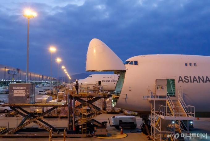 2021년 12.19일 인천국제공항 아시아나항공 화물터미널에서 관계자들이 화물기에 수출화물을 탑재하고 있다. /사진=이기범 기자 leekb@