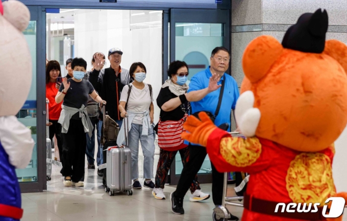 (인천공항=뉴스1) 박정호 기자 = 중국인 단체 관광객들이 지난 24일 오후 인천국제공항을 통해 입국하며 손을 흔들어 인사하고 있다. 한국관광공사는 중국 방한 관광시장 정상화에 따른 중국 방한단체 맞이 환대 행사를 열고 이날 입국한 관광객들에게 꽃다발과 기념품을 전달했다. (공동취재) /뉴스1 Copyright (C) 뉴스1. All rights reserved. 무단 전재 및 재배포 금지.