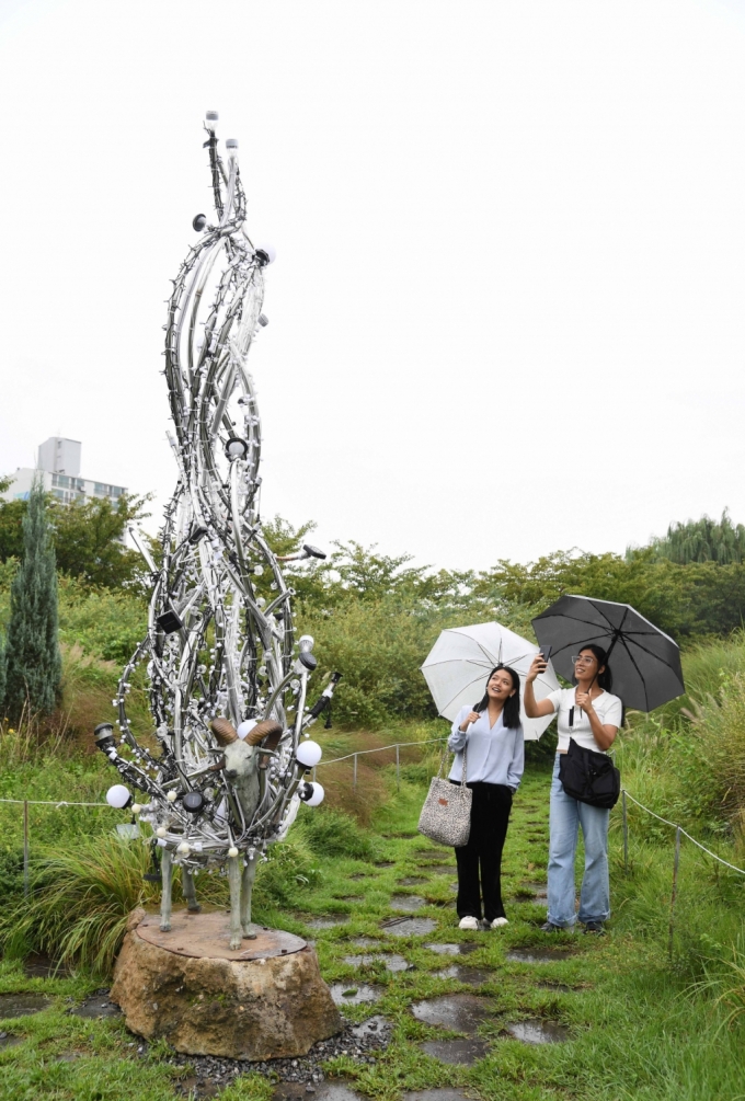 뚝섬한강공원에서 열린 2023 한강조각프로젝트에서 시민들이 '송필' 작가의 '실크로드' 작품을 감상하고 있다
