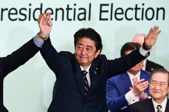 = 아베 신조 일본 총리가 20일 (현지시간) 도쿄 자민당 당사에서 총재 3연임에 성공한 뒤 축하를 받고 있다.   (C) AFP=뉴스1  