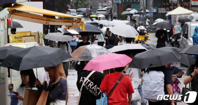 가을비가 내리는 13일 오후 서울 마포구 홍대입구역 사거리에서 우산을 쓴 시민들이 발걸음을 재촉하고 있다. /사진=뉴스1