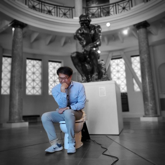 박승민 미국 스탠퍼드대 비뇨기의학과 박사가 로댕의 생각하는 사람 조각상 앞에서 자신이 만든 스마트 변기에 앉아 있다. / 사진=박승민 박사 X(옛 트위터)