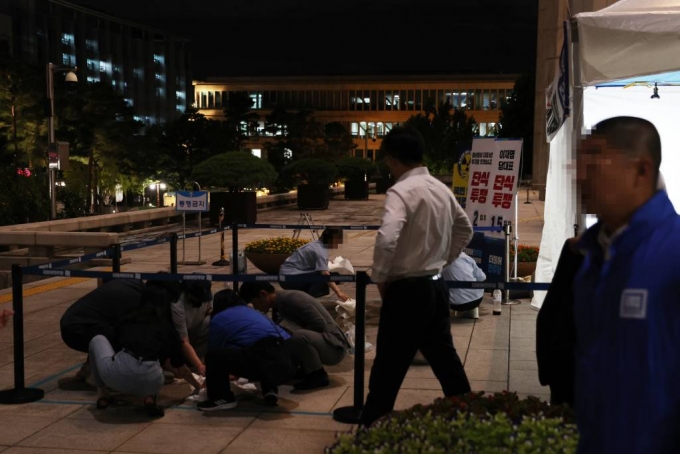 지난 14일 밤 국회 본관 앞 단식 농성장에서 50대 여성 소란행위로 국회경비대의 제지를 받던 도중 흉기를 휘둘러 여경에게 상해를 입혔다. 민주당 관계자들이 사건 현장을 정리하고 있다. /사진=뉴시스