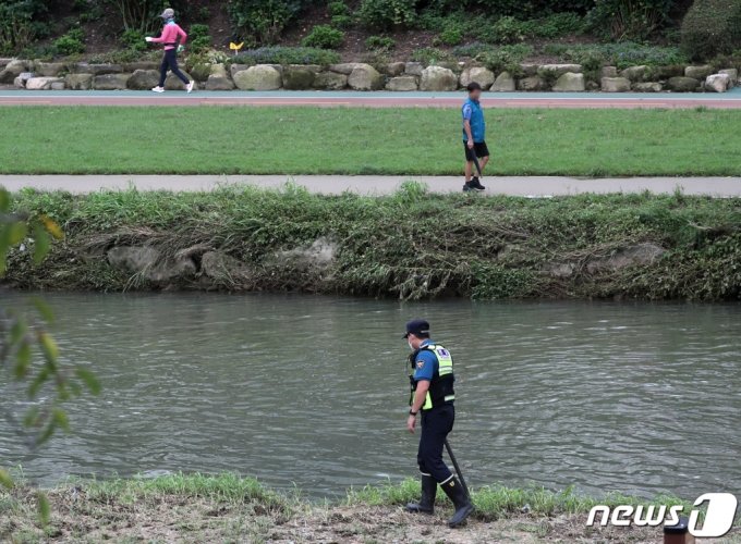 지난 21일 오후 부산 동래구 온천천 산책로 일대에서 경찰이 전날 폭우로 불어난 물에 휩쓸려 실종된 여성을 찾기 위한 수색작업을 하고 있다. /사진=뉴스1
