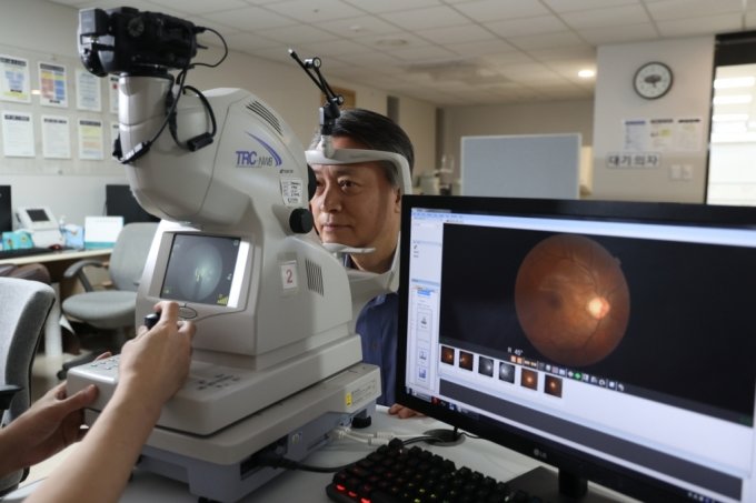 60대 남성이 망막 질환을 확인하기 위해 안저검사를 받고 있다./사진=김안과병원