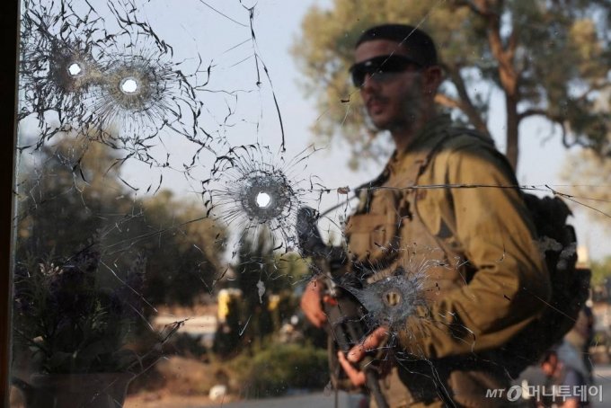  이스라엘 남부 키부츠 베이리에서 하마스 무장세력이 가자지구에 대규모로 침투한 후 이스라엘 군인이 총탄 자국 옆을 걷고 있다.