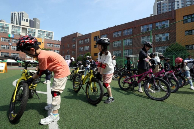 [서울=뉴시스] 조성봉 기자 = 3일 오전 서울 서초구 서울원명초등학교에서 열린 ‘초등 찾아가는 자전거타기 안전교실’에서 학생들이 자전거를 타기 전 자전거 바퀴 상태를 확인하고 있다. 2023.07.03.