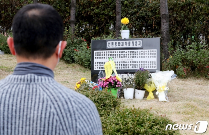 (인천=뉴스1) 정진욱 기자 = 29일 오후 인천시 중구 인천학생교육문화회관 가온갤러리에서 인현동 화재참사 21주기 추모전 ‘기억의 싹’ 전시가 열린 가운데 한 시민이 추모비를 바라보고 있다.11월 7일까지 열리는 이번 추모전은 10여 명의 지역작가 및 미술교사들이 참여하여 1999년 10월 30일 인현동 상가 화재로 희생된 57명의 학생들을 추모하는 그림과 사진을 전시한다. 2020.10.29/뉴스1
