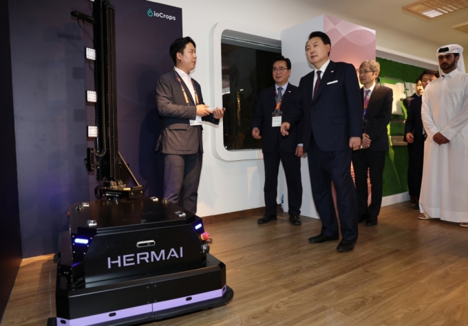 [도하=뉴시스] 전신 기자 = 카타르를 국빈 방문한 윤석열 대통령이 24일(현지시간) 도하 알 비다 공원에서 열린 국제원예박람회 한국관 개관식에 참석, 한국형 스마트 농업 전시관을 찾아 조진형(왼쪽) 아이오크롭스 대표로부터 생육 모니터링 자율주행 작물관찰로봇 헤르마이에 대한 설명을 듣고 있다. 왼쪽 두번째는 정황근 농림축산식품부 장관. 2023.10.25. photo1006@newsis.com