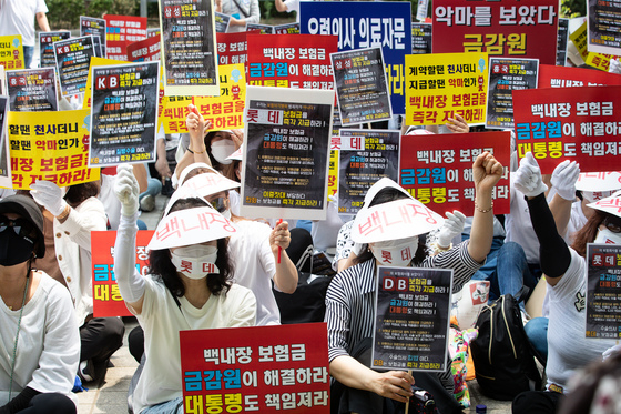 (서울=뉴스1) 유승관 기자 = 백내장 미지급 보험금 피해자들이 13일 서울 여의도 금융감독원 앞에서 집회를 열고 백내장 미지급 보험금 즉각 지급을 촉구하는 구호를 외치고 있다. 이들은 '노안 백내장' 등으로 안과 전문의에게 진단 및 수술을 받고 보험금을 청구 했으나, 보험회사 측의 '의료자문 동의'에 응해 지급사유에 해당하지 않았다며 보험금 지급이 거절되거나 '의료자문 비동의'를 사유로 보험금 지급을 거부하고 있다고 주장했다. 2022.6.13/뉴스1