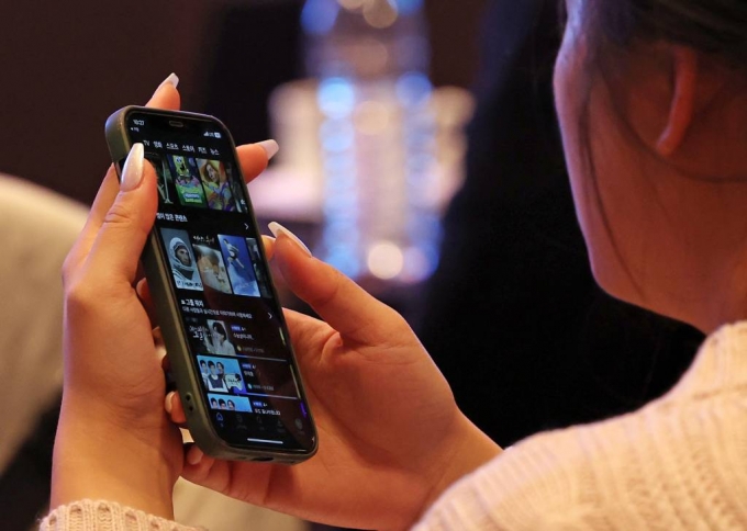 지난해 11월 서울 중구 앰배서더 서울 풀만 호텔에서 열린 국제 OTT 포럼에서 한 참석자가 휴대폰 OTT 화면을 보고 있다. /사진=뉴시스
