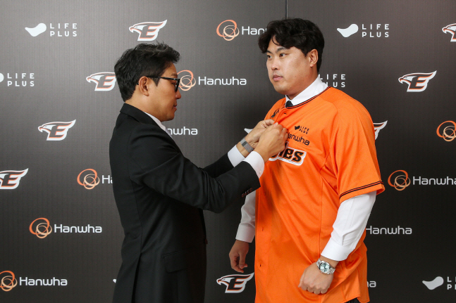 박찬혁 대표(왼쪽)가 22일 한화 입단 계약을 마친 류현진에게 유니폼을 입혀주고 있다. /사진=한화 이글스