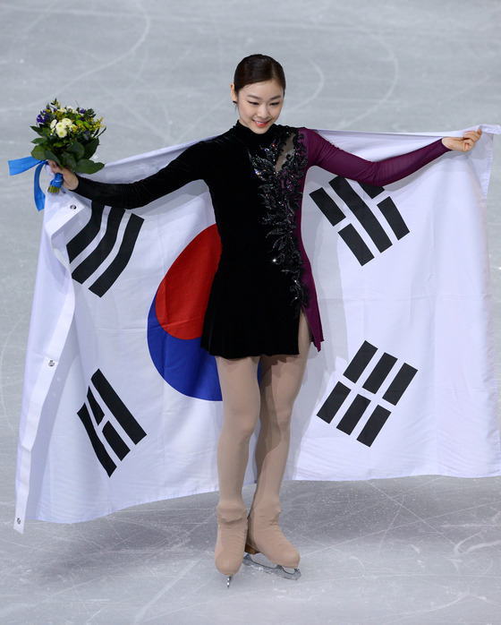 전 피겨스케이팅 선수 김연아. 2014 소치동계올림픽이 진행 중이던 2014년 12월21일(한국시간), 김연아가 러시아 소치 해안 클러스터 아이스버그 스케이팅 팔라스 경기장에서 열린 프리 스케이팅 경기 후 꽃다발과 태극기를 들고 취재진을 향해 포즈를 취하고 있다. 김연아는 144.19점을 받아 전날 쇼트에서 받은 74.92점을 합산해 총점 219.11점으로 러시아의 소트니코바에 이어 은메달을 차지했다. /사진=뉴스1