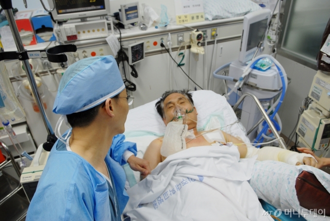 이국종 국군대전병원장(당시 아주대병원 교수)이 2011년  '아덴만 여명 작전'에서 총상을 입은 석해균 삼호주얼리호 선장을 성공적으로 수술한 후 대화하고 있는 모습. / 사진=머니투데이DB