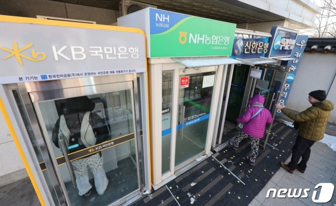 (서울=뉴스1) 신웅수 기자 = 2023년2월 21일 서울 시내 시중은행 ATM 기기를 이용하는 시민들의 모습. 2023.12.21/뉴스1 Copyright (C) 뉴스1. All rights reserved. 무단 전재 및 재배포, AI학습 이용 금지.