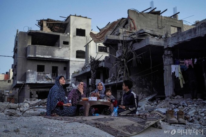이스라엘과 무장정파 하마스간 전투가 지속되고 있는 가운데 11일(현지시간) 가자지구 중부 데이르엘발라에서 일가족이 이슬람 금식성월 라마단 첫날 식사를 하고 있는 모습./AFPBBNews=뉴스1 /사진=(AFP=뉴스1) 정윤영 기자