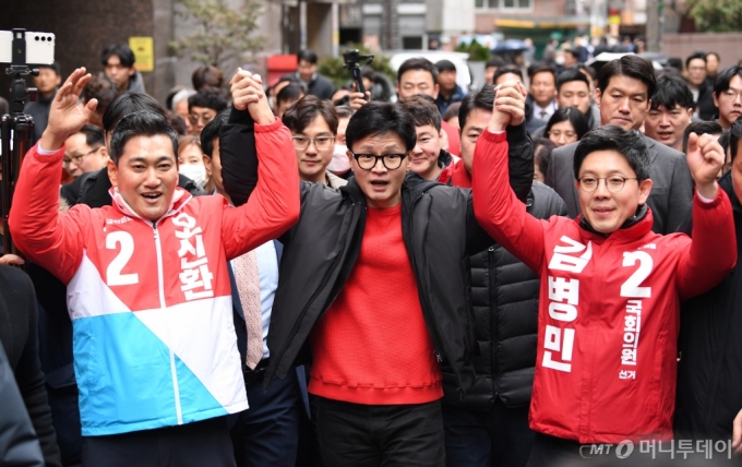 [서울=뉴시스] 조성봉 기자= 한동훈 국민의힘 비상대책위원장이 20일 서울 광진구 화양동에서 '시민이 안전한 대한민국' 현장 공약을 발표하기 위해 이동하며 단수공천을 받은 김병민 광진 갑 후보, 오신환 광진을 후보와 함께 손을 들고 있다.(공동취재)2024.02.20. photo@newsis.com /사진=