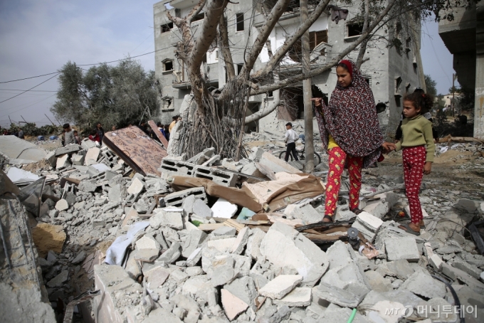  29일(현지시간) 가자지구 남부 라파에서 팔레스타인 주민들이 이스라엘의 공습으로 파괴된 건물 상태를 살피고 있다. /AP=뉴시스 /사진=민경찬