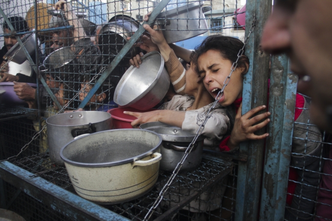 [가자지구=AP/뉴시스] 18일(현지시각) 가자지구 자발리아 난민촌에서 팔레스타인 어린이들이 무료 급식을 받기 위해 몰려들고 있다. 2024.03.19.