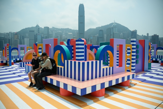 홍콩 하버시티 쇼핑몰을 찾은 고객들이 12일 야외에 설치된 프랑스 예술가 카미유 왈랄라의 작품 '왈랄라의 행성'에 앉아 쉬고있다. 2024.04.12  /AFPBBNews=뉴스1