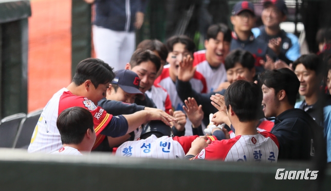 황성빈(가운데)이 21일 더블헤더 1차전에서 홈런을 친 뒤 더그아웃에서 동료들로부터 축하 인사를 받고 있다. /사진=롯데 자이언츠 제공