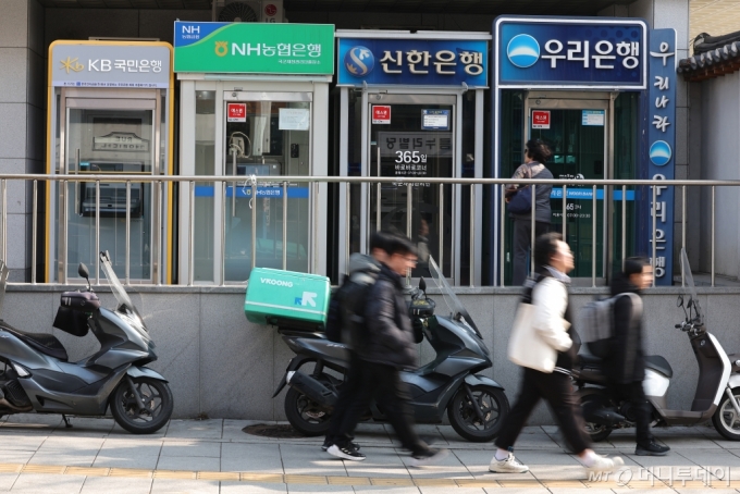 (서울=뉴스1) 신웅수 기자 = 현금자동인출기(CD)와 현금자동입출금기(ATM) 이용액이 19년 만에 가장 낮은 수준으로 감소한 13일 서울 시내에 설치된 시중은행 ATM 기기 앞을 시민들이 지나가고 있다.   한국은행 경제통계시스템(ECOS)에 따르면 'CD 공동망'을 통한 계좌이체와 현금인출 등의 금액이 지난 1월 14조8485억 원으로 나타났다.   이는 지난 2005년 2월(14조5316억 원) 이후 18년11개월 만의 최저치다.   인터넷 뱅킹과 모바일 서비스가 보편화함과 동시에 현금 없는 사회로의 전환이 지속된 /사진=(서울=뉴스1) 신웅수 기자