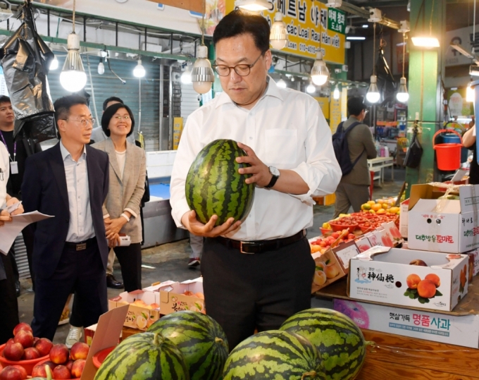 김병환 기획재정부 차관이 24일 오후 대전 소상공인 민생현장 현장방문차 대전 서구 도마큰시장을 방문, 온누리상품권으로 수박을 구매하고 있다./사진제공=기재부