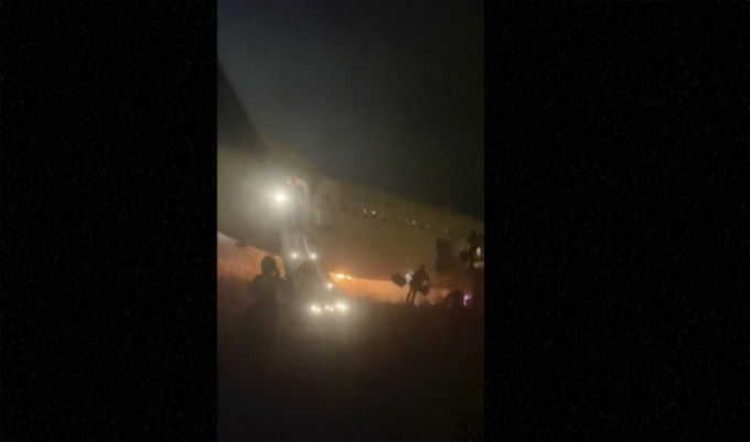 비디오 영상 캡처 사진에 지난 5월 8일(현지시각) 세네갈 다카르의 블레즈디아뉴 국제공항에서 여객기가 활주로를 이탈한 후 화재가 발생해 승객들이 비상 슬라이드를 통해 탈출하고 있다. 이날 승객 85명을 태운 트랜스에어 소속 보잉 737-300 여객기가 이륙 중 활주로를 벗어나 잔디밭에 처박혀 10명이 다친 것으로 나타났다/AP=뉴시스