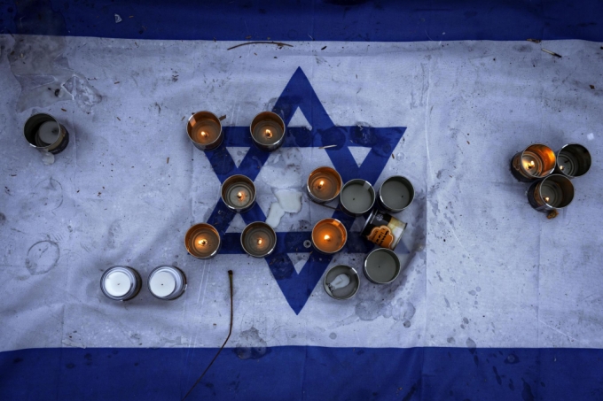  이스라엘 텔아비브 시내에 놓인 이스라엘 국기 위에 지난해 10 7일 하마스에 살해되고 납치된 이스라엘 사람들의 명복과 귀환을 기원하는 촛불이 놓여 있다. /AP=뉴시스