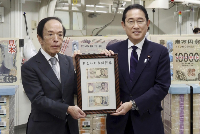 기시다 후미오(오른쪽) 일본 총리가 3일 일본 도쿄의 일본중앙은행(BOJ)에서 우에다 가즈오 BOJ 총재와 함께 새로 발행한 지폐 3종을 들고 기념 촬영하고 있다. 최고액권인 1만 엔(약 8만6000원)에는 한국 경제 침탈의 주역인 '시부사와 에이이치'의 초상화가 들어가 논란이 일고 있다. 2024.07.03. /AP=뉴시스