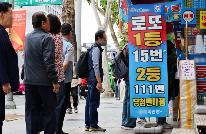 [서울=뉴시스] 김근수 기자 = 30일 오전 서울 시내의 한 복권방에서 복권을 사려는 시민들로 붐비고 있다.   통계청 가계동향조사 마이크로데이터를 분석한 결과 지난 1분기 로또·연금복권·경마·경륜 등의 복권을 구매한 가구는 221만2천가구로 조사 대상 가구(2천183만4천가구)의 10.1%를 차지해 5년간 가장 큰 비중을 차지했다. 2024.05.30. 